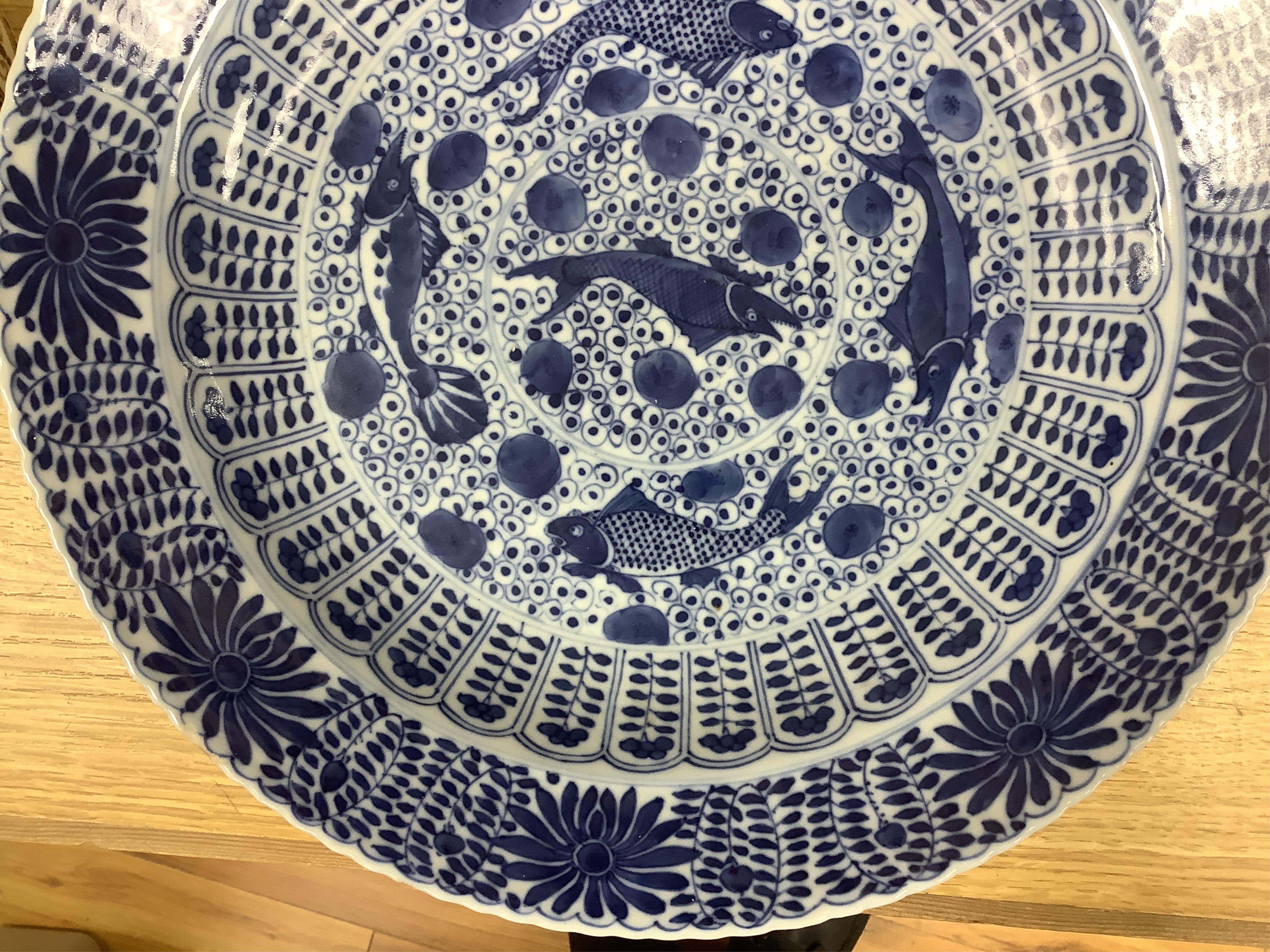 A Chinese blue and white 'fish' dish, Kangxi mark but c.1900, 33cm diameter. Condition - slight chipping to rim